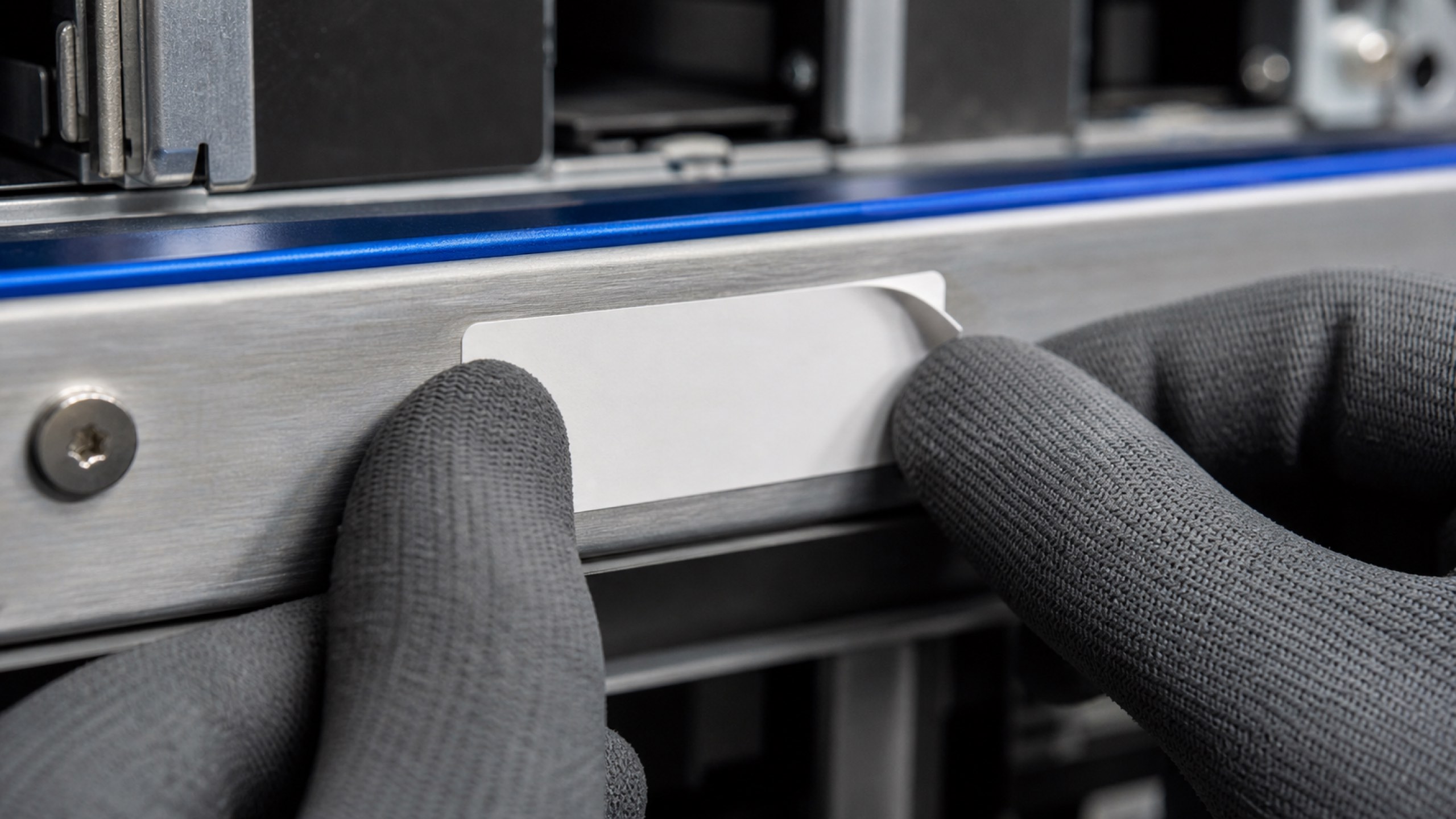 A serialized asset label being checked against the packing record before a unit is boxed.